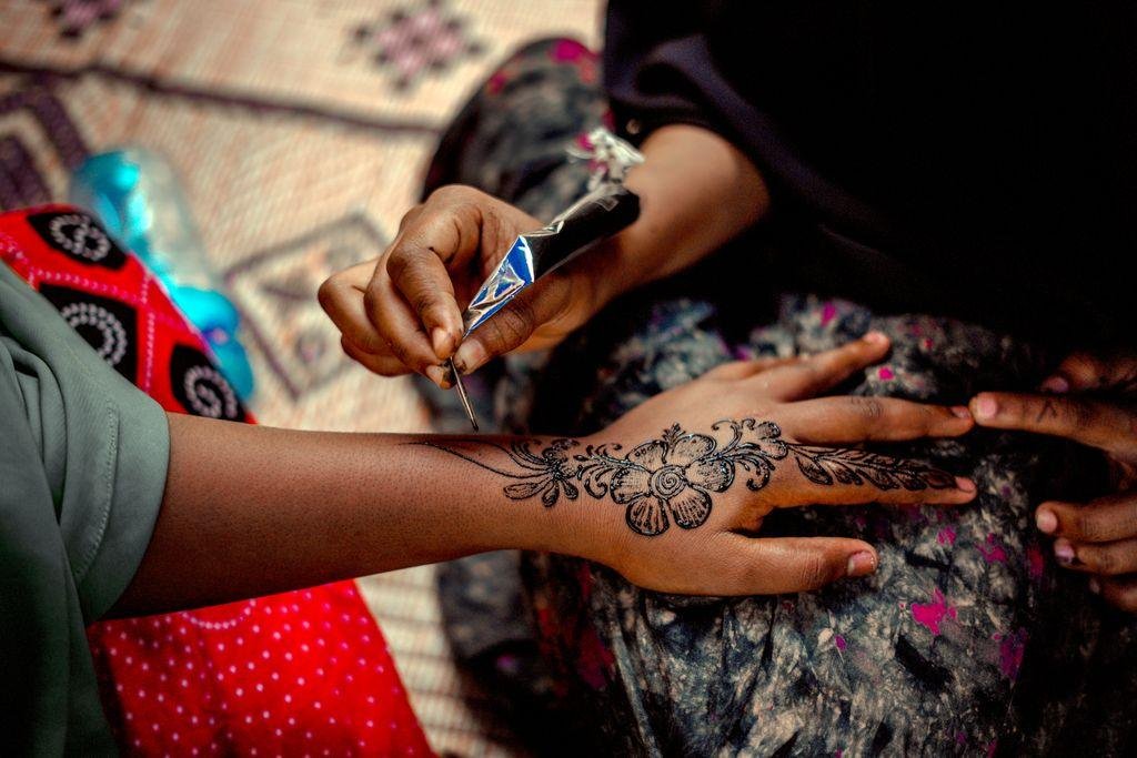 A detailed henna design is applied to a person's hand, showcasing cultural artistry.