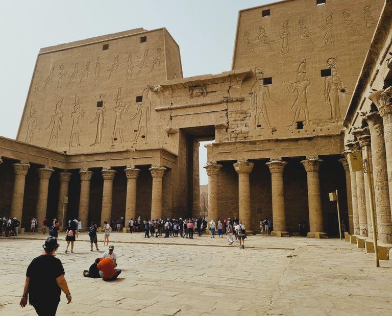 Visitors exploring the ancient Temple of Horus in Edfu, Egypt with rich hieroglyphs and architecture.