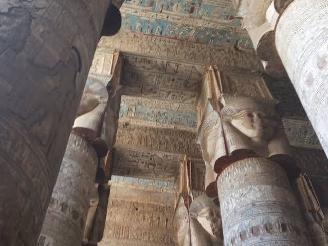 Hathor-headed columns and astronomical ceiling inside Dendera Temple.