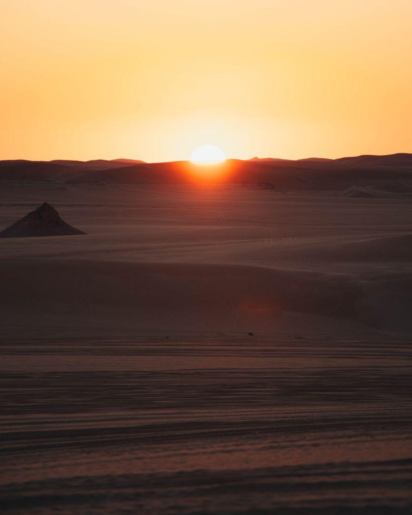 A breathtaking sunset over the dunes of Siwa Oasis, Egypt, capturing the warmth and serenity of the desert landscape.