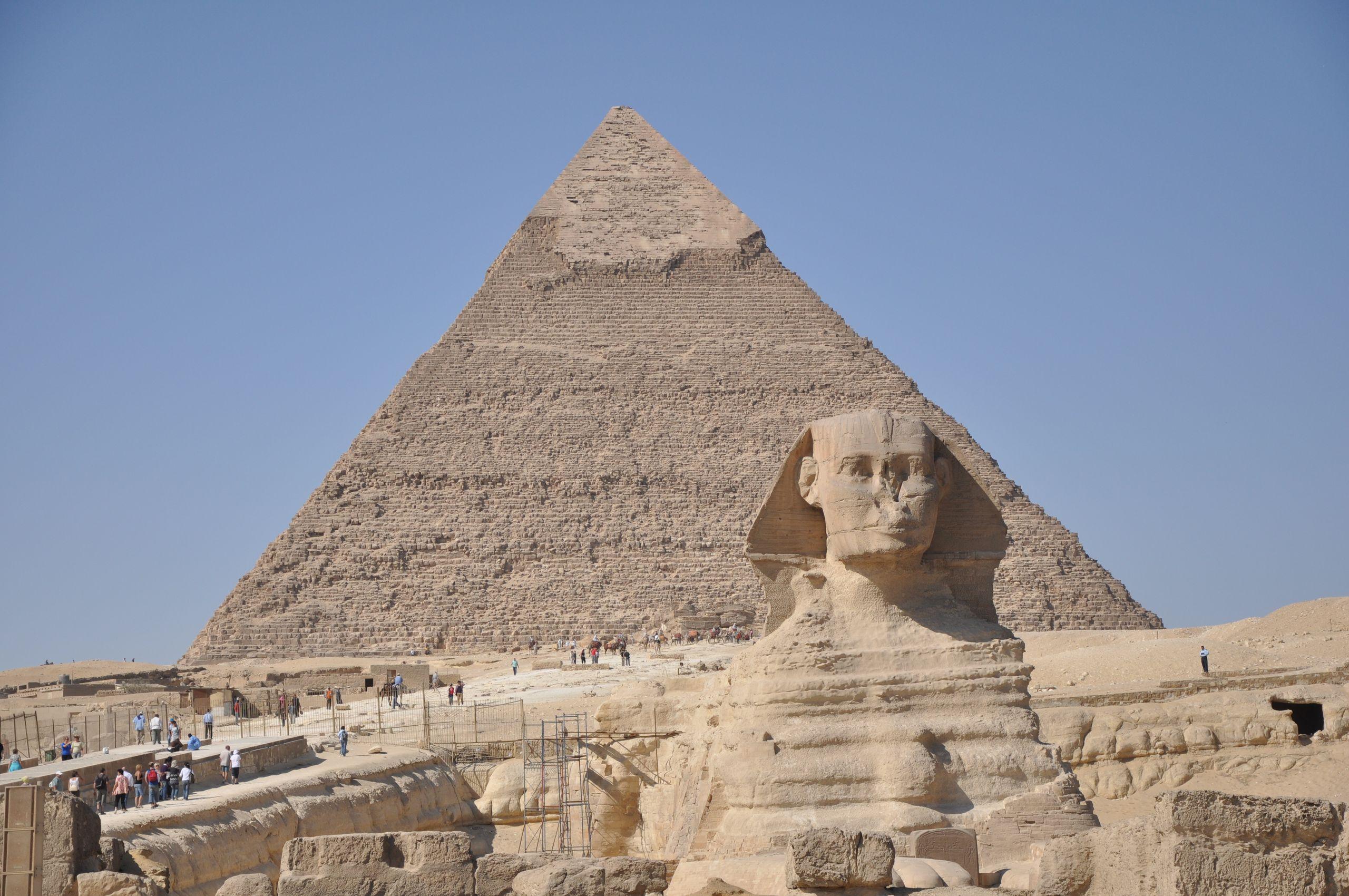 Iconic Sphinx with Great Pyramid in Giza, Egypt, under a clear blue sky.