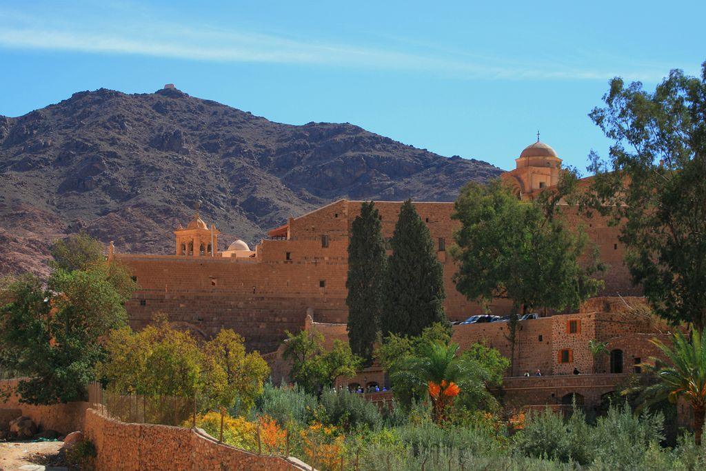 St. Catherine's Monastery, surrounded by Sinai mountains, under clear sky.